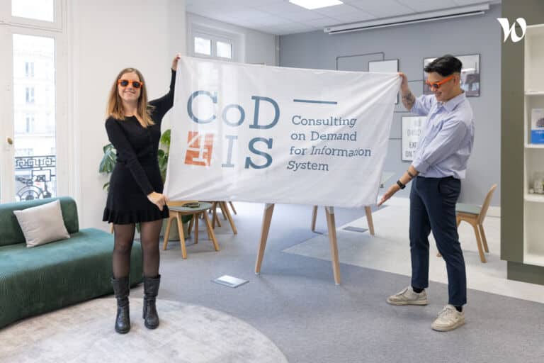 Ninon Loquet et Eric Duong déployant le drapeau de COD4IS dans les locaux de l'entreprise