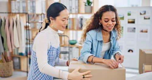 2 vendeuses en magasin préparent un colis pour expédier une commande client